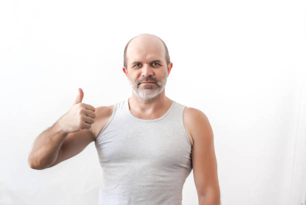 istock Man strong physique points the thumb up 899625256