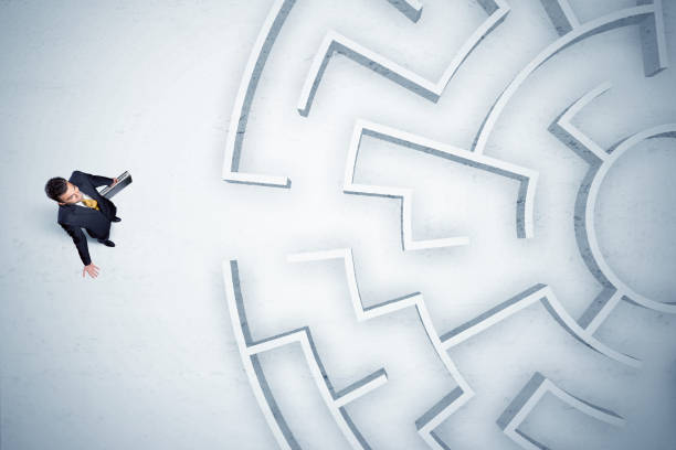istock Business man looking at circular maze with nowhere to go 899636504
