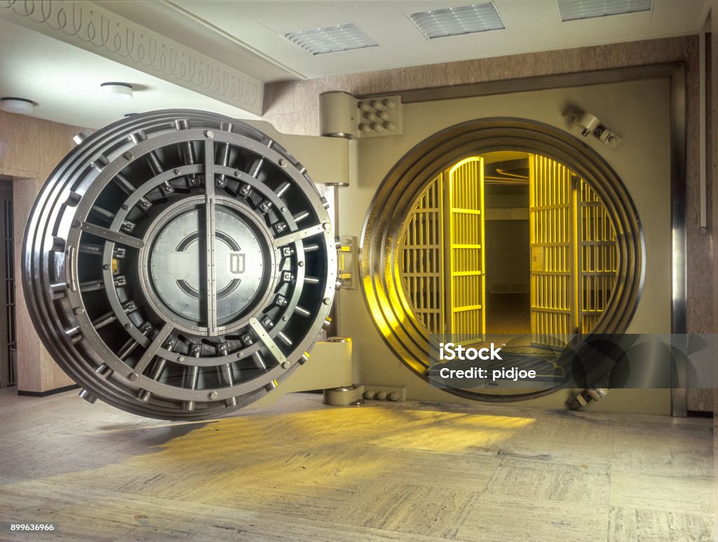 Very large Open Safe With golden  Light shining from within the safe. Vaulted Door Stock Photo