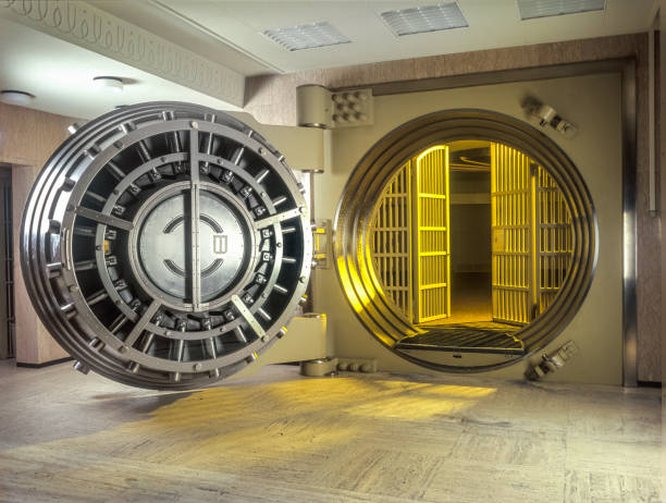 very large open safe with golden  light shining from within the safe. - lock currency security combination lock imagens e fotografias de stock