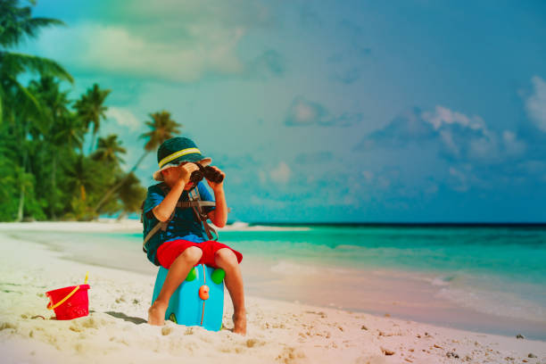 istock little boy travel on beach with backpack and suitcase 899639550