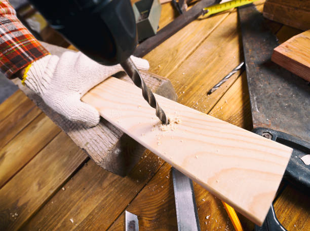 istock Man drills the wooden plank 899639776
