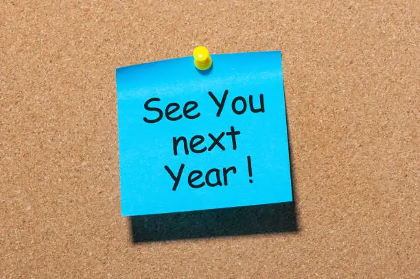 phrase See you next year pinned at cork board.