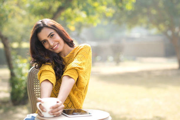 istock Beautiful woman drinking coffee at park 899641082