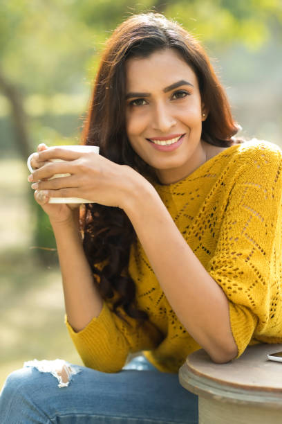 istock Indian woman drinking coffee at park 899645028