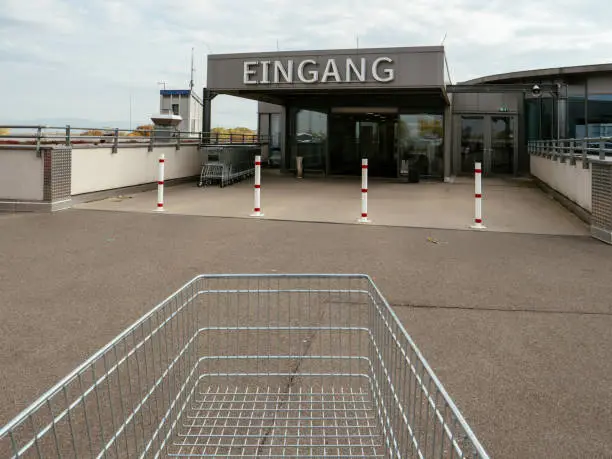 Street view of Supermarket cart in front of the entrance with Eingang translated as Entrance in german city