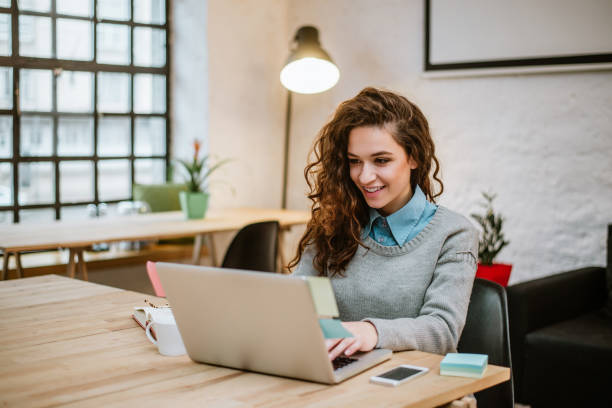 Successful young woman in modern office working on laptop. Successful young woman in modern office working on laptop. job search stock pictures, royalty-free photos & images
