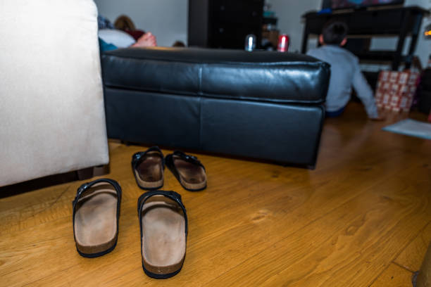 istock Two sets of slippers on the floor next sofa christmas party 899658910