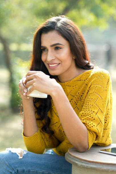 istock Indian woman drinking coffee at park 899658976