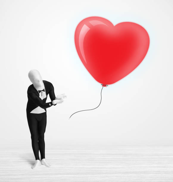 istock Cute guy in morpsuit body suit looking at a balloon shaped heart 899670238