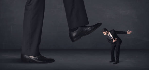 istock Giant person stepping on a little businessman concept 899670430