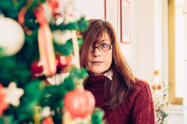 istock Mature Woman Decorating Christmas Tree 899670996