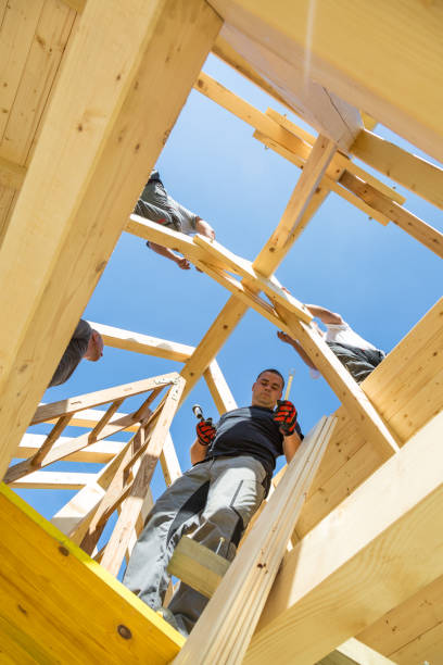 istock Builders at work with wooden roof construction. 899674220