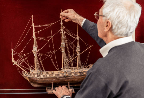 istock Senior Man Checking Handmade Wooden Sailboat Model 899680084