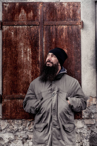 istock Portrait Of Man With Beard Standing In Front Of Rusty Metal Shutter 899680170