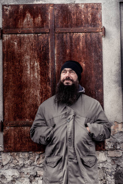 istock Portrait Of Man With Beard Standing In Front Of Rusty Metal Shutter 899680204