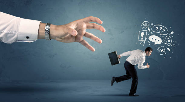 istock Business man running from a big hand 899683394