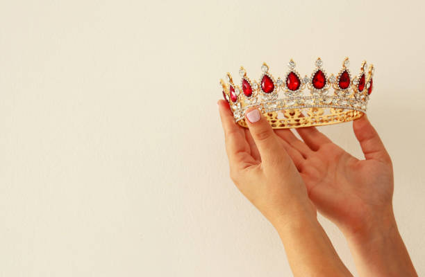 istock Woman's hand holding a crown for show victory or winning first place. White background. Copy space. Isolated. 899683572