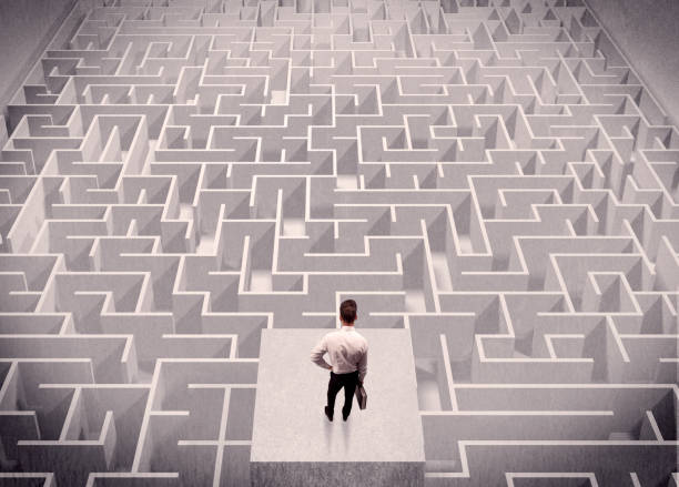 istock Businessman looking at labirynth from above 899684100