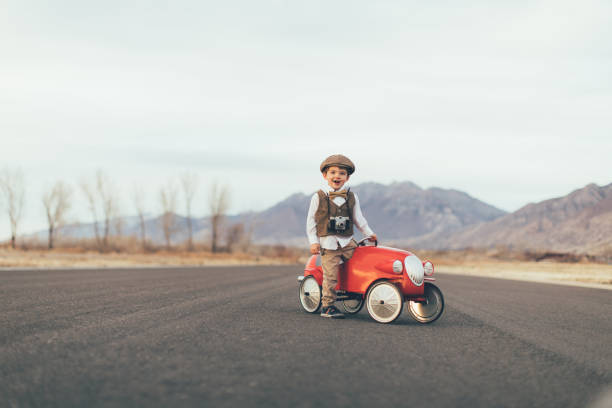 istock Young Vintage Boy Drives Toy Car 899687486
