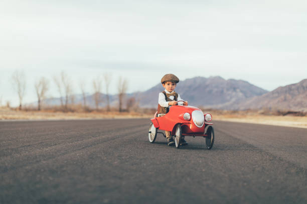 istock Young Vintage Boy Drives Toy Car 899687490