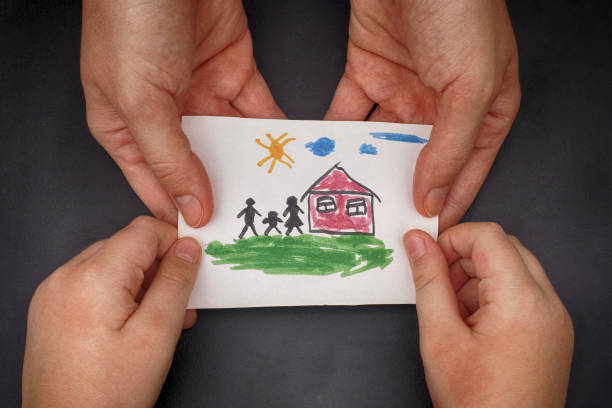 istock Child and his mom holding a drawn house with family 899687708