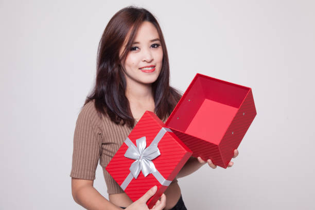 istock Young Asian woman open a golden gift box. 899690738