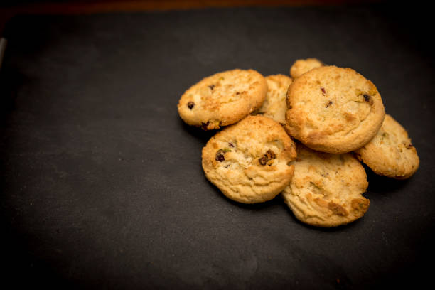 deliziosi, deliziosi e lussuosi biscotti di pistacchio al forno a casa e cioccolato a base di cioccolato appoggiati su uno sfondo di ardesia nera - biscotti cookie chocolate pistachio foto e immagini stock