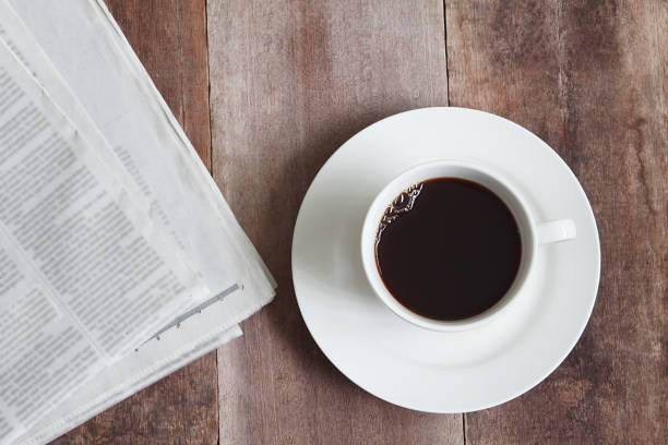 istock White coffee cup and news paper on wood table 899701398