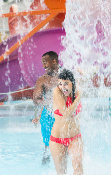istock Two young adults having fun at a water park 899704384