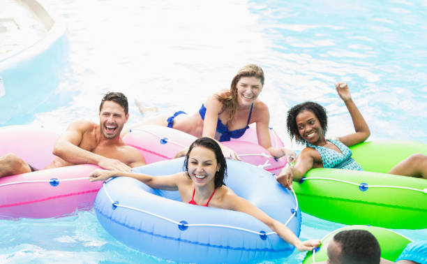 istock Multi-ethnic group of friends on inflatable rings 899704506