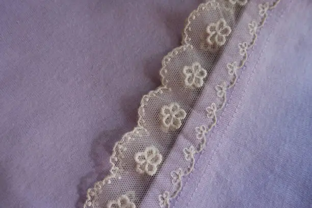 Photo of Frill of ivory lace sewn to mauve fabric