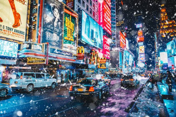 persone e famosi pannelli pubblicitari a led a times square durante la neve, uno dei simboli di new york city. - dusk people manhattan new york city foto e immagini stock