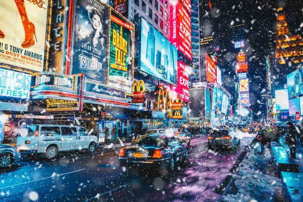 pessoas e painéis de publicidade conduzida famosa na times square durante a neve, um dos símbolos da cidade de nova york. - times square billboard street night - fotografias e filmes do acervo