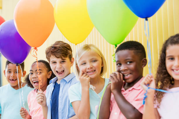 istock Multi-ethnic group of children in a row, with balloons 899708262