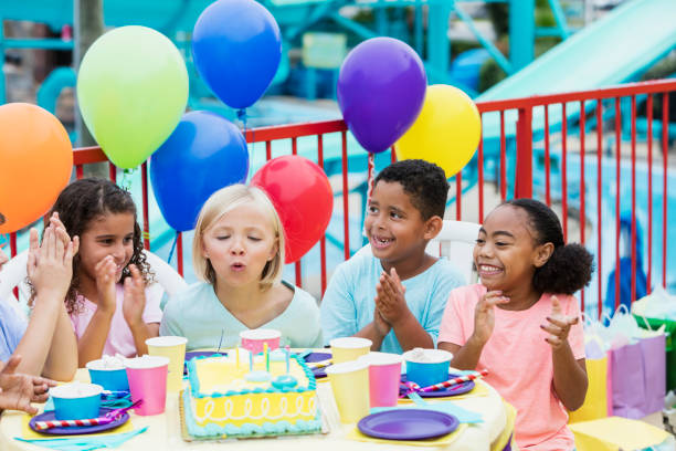 istock Multi-ethnic children, blowing out birthday candles 899708268