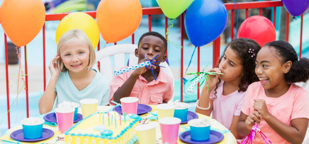 istock Children at birthday party with horns, laughing 899708514