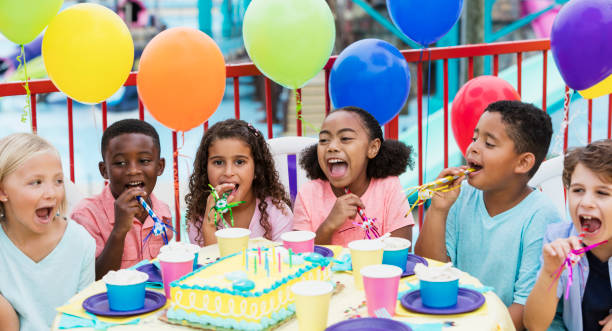istock Children at birthday party with horns 899708616