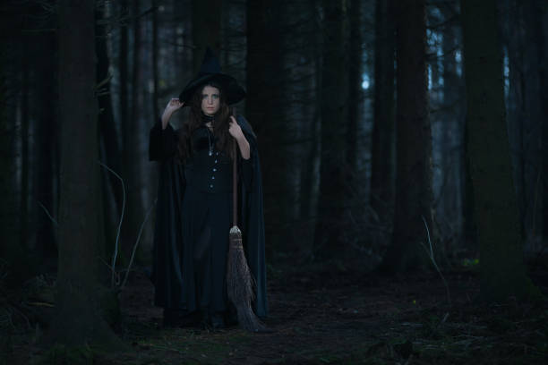 istock Witch with a broom in the forest 899708938