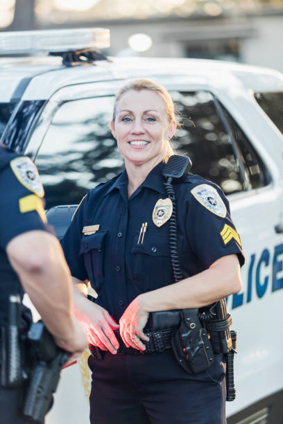 istock Policewoman and partner next to squad car 899708954