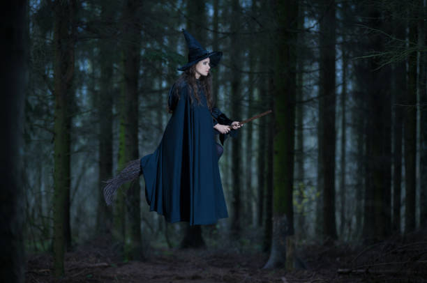 strega che vola su una scopa nella foresta - victorian style women dress night foto e immagini stock