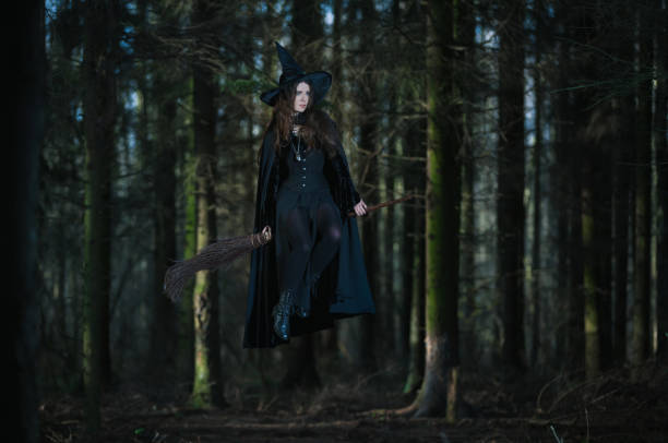 istock Witch flying on a broom in the forest 899711244