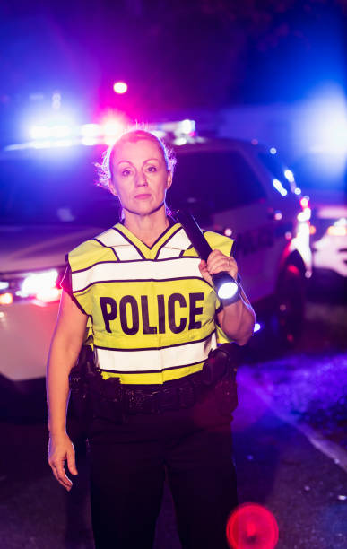 istock Policewoman at night with flashlight, emergency lights 899711416