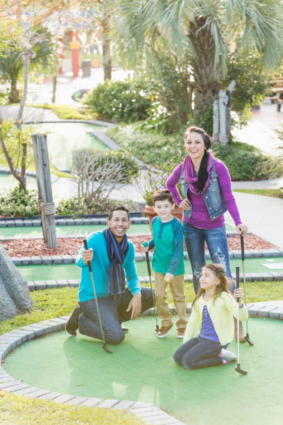 rodzina gra w minigolfa - standing family golf loving zdjęcia i obrazy z banku zdjęć