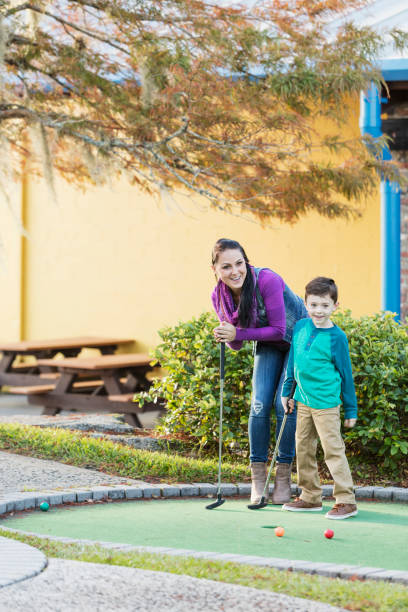 istock Mother and son playing miniature golf 899712402