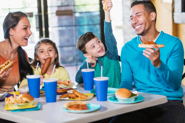 Family With Two Children Eating Fast Food Stock Photo - Download Image Now  - Family, Eating, Restaurant - iStock