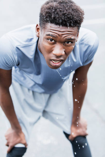 Young man taking a break after play basketball on sport court