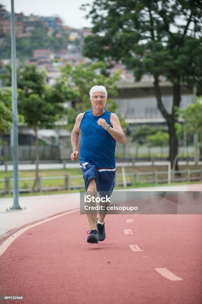 Senior walking Senior walking on a street racetrack as physical activity Jogging Stock Photo