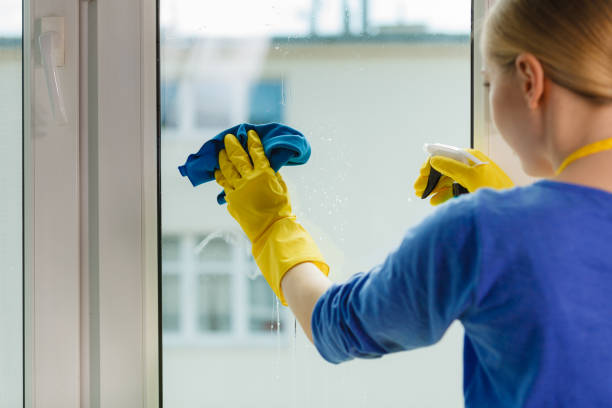istock Girl cleaning window at home using detergent rag 899731712