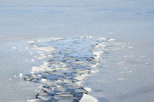 Agujero en el hielo fino. Alguien bajó a través del hielo. Concepto peligroso. Congelación y fusión tiempo de hielo en los depósitos de agua en invierno. photo